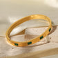 gold bangle C&L Jewellery with green zircons